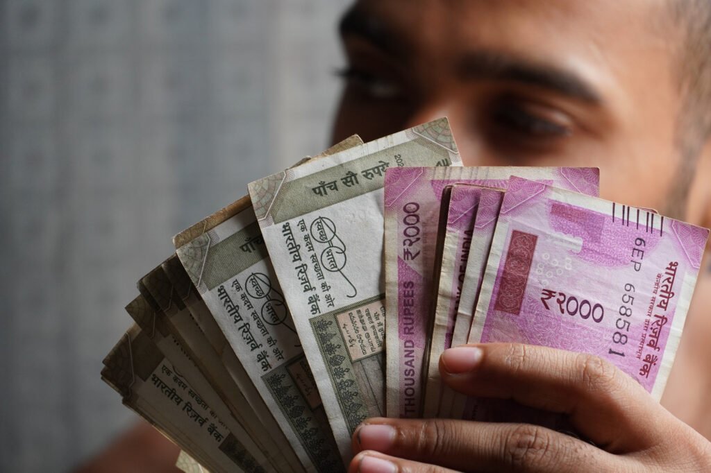 In ths a person is showing indian currency note